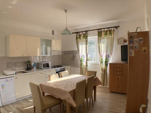 a kitchen with a table and chairs in a kitchen at Apartments by the sea Lun, Pag - 9395 in Lun