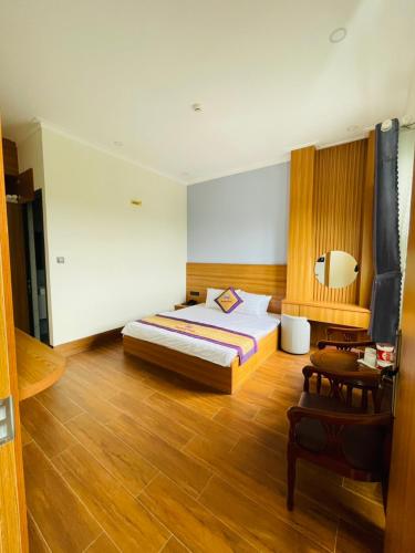 a bedroom with a bed and a table and a chair at Khách sạn Sớm Phú Quý 2 - Phan Rang in Phan Rang