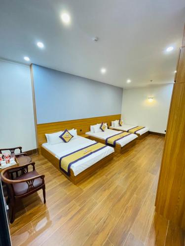 a room with three beds and a large window at Khách sạn Sớm Phú Quý 2 - Phan Rang in Phan Rang