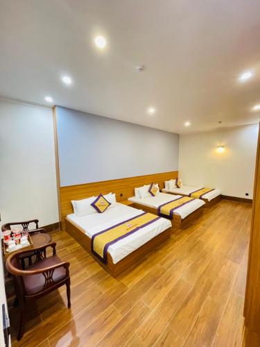 two beds in a room with wooden floors at Khách sạn Sớm Phú Quý 2 - Phan Rang in Phan Rang