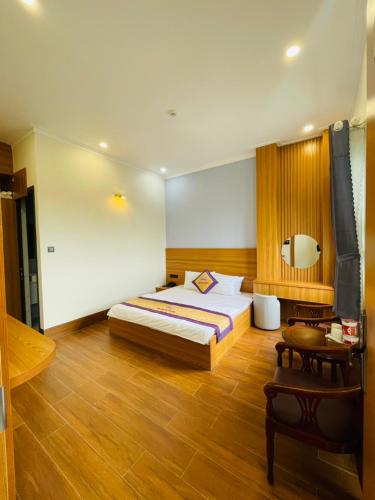 een slaapkamer met een bed en een houten vloer bij Khách sạn Sớm Phú Quý 2 - Phan Rang in Phan Rang