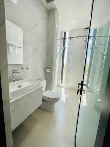 a white bathroom with a toilet and a sink at Khách sạn Sớm Phú Quý 2 - Phan Rang in Phan Rang