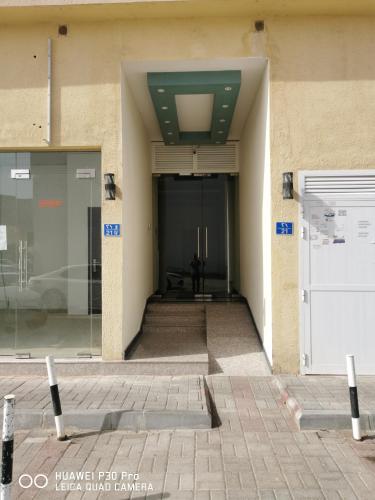 a hallway leading to a building with a door at Amazing 2BR pent house flat with mountain view in Muscat