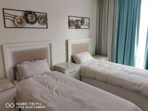 a bedroom with two beds and a window at Amazing 2BR pent house flat with mountain view in Muscat