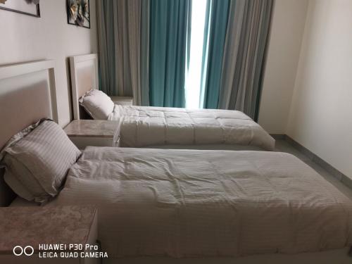 a bedroom with two beds and a mirror at Amazing 2BR pent house flat with mountain view in Muscat