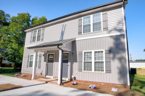 a white house with a garage at Kannapolis Elegant Townhouse - Pet Friendly in Kannapolis