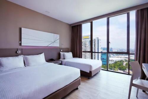 um quarto de hotel com duas camas e uma grande janela em Hotel Damansara Perdana - Q em Petaling Jaya