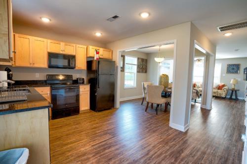 a kitchen and living room with wooden floors and appliances at Kannapolis Elegant Townhouse - Pet Friendly in Kannapolis