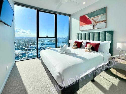 a bedroom with a large bed and large windows at Luxury S Casino Residences Broadbeach - Holiday Paradise in Gold Coast