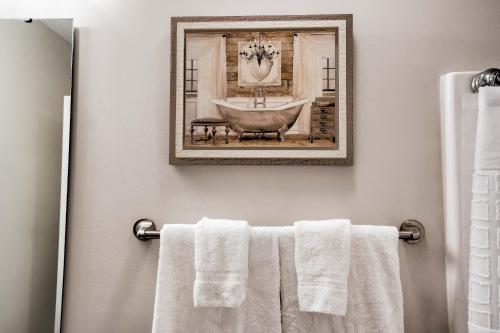 uma casa de banho com uma fotografia de uma banheira e toalhas em Kannapolis Elegant Townhouse - Pet Friendly em Kannapolis
