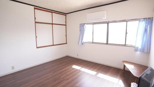 um quarto vazio com uma cadeira e uma janela em 楠のおうち em Yokkaichi
