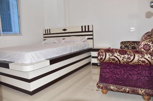 a bed and a chair in a room at Hotel KDISSON in Mohaniā