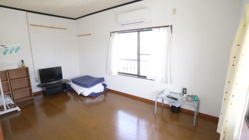a living room with a large window and a television at 楠のおうち in Yokkaichi