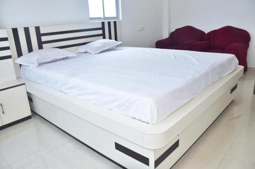 a large white bed sitting in a bedroom at Hotel KDISSON in Mohaniā