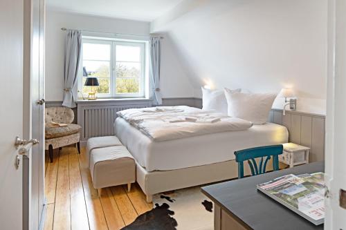 una camera da letto con un letto, una scrivania e una finestra di Hobooken Hüs a List