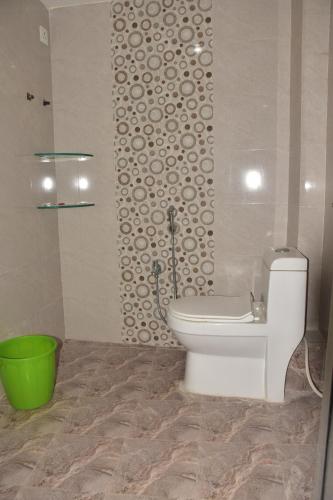 a bathroom with a toilet and a green bucket at Hotel KDISSON in Mohaniā