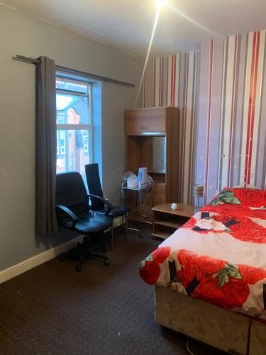 a hotel room with a bed and a chair and a window at Budget house with wifi and parking close to amenities in Burton upon Trent