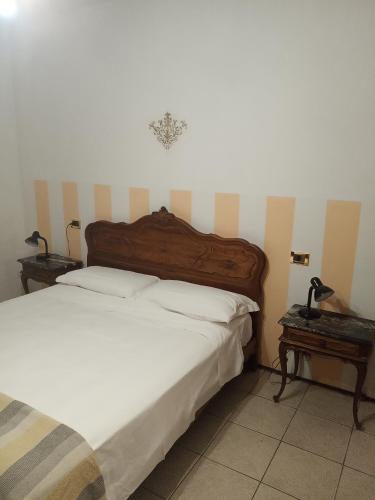 a bedroom with a bed and two tables with lamps at Bed & breakfast Mezzaluna in Feletto