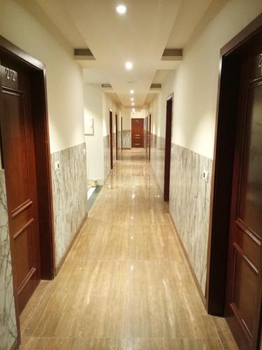 a hallway of a building with wooden floors and doors at HOTEL NEW ANAND PALACE in Alīgarh