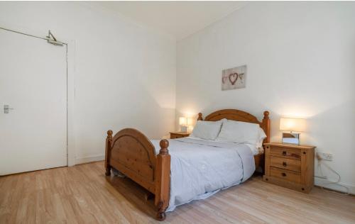 a bedroom with a bed and a night stand with two lamps at Newhall in Glasgow