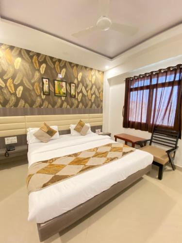 a bedroom with a king sized bed and a checkerboardboard wall at Hotel Gomti Dwarka in Dwarka