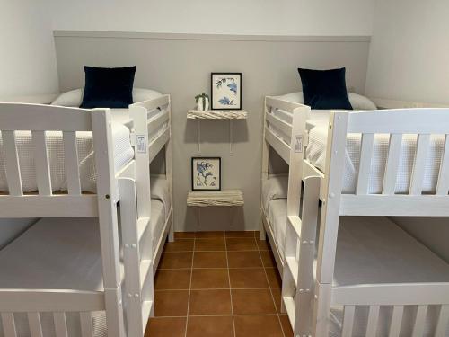 two white bunk beds in a room at Casa rural La Alcaparra in Écija