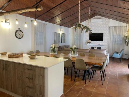 a kitchen and dining room with a table and a couch at Casa rural La Alcaparra in Écija