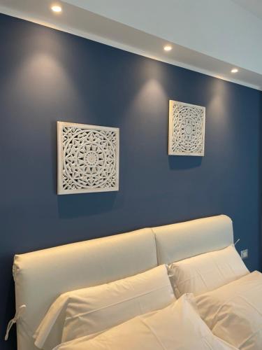 1 dormitorio con 1 cama blanca y 2 cuadros en la pared en Luxury Sea House, en Trapani