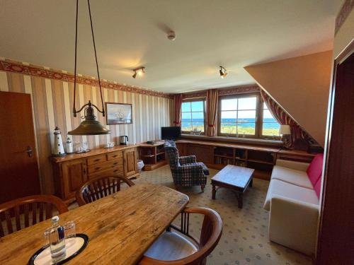 ein Wohnzimmer mit einem Tisch und einem Sofa in der Unterkunft Moby Dick Hotel & Ferienwohnungen in Wustrow