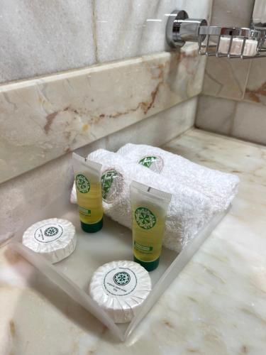 - un lavabo avec 2 tasses et des serviettes en papier dans l'établissement دار بنيان 2, à Al Khansāk