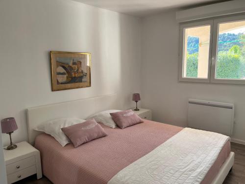 ein Schlafzimmer mit einem Bett mit zwei Kissen und einem Fenster in der Unterkunft Trés belle suite prés mer et golf avec piscine in Saint-Côme
