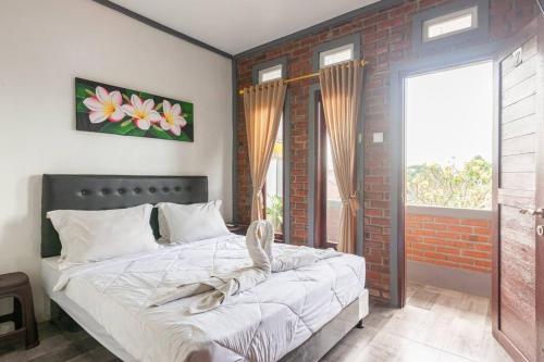 a bedroom with a bed and a brick wall at The Backyard House in Tabanan
