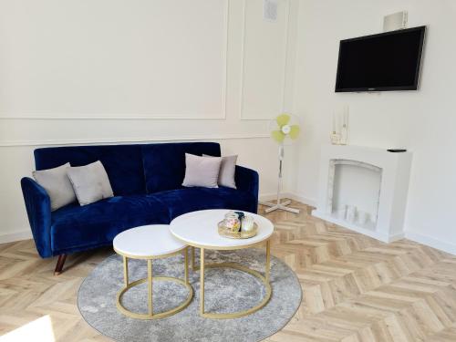 - un salon avec un canapé bleu et une table dans l'établissement Sun and holidays apartament Abrahama, à Gdynia
