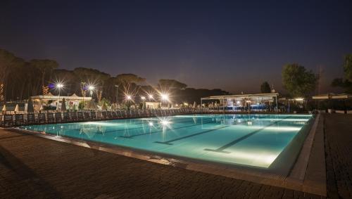 a swimming pool at night with lights at Fabulous village in Casal Palocco
