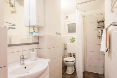 Baño blanco con aseo y lavamanos en Oktogon City Apartment, en Budapest