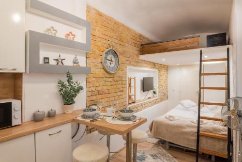 Habitación pequeña con cama y cocina con mesa. en Oktogon City Apartment, en Budapest