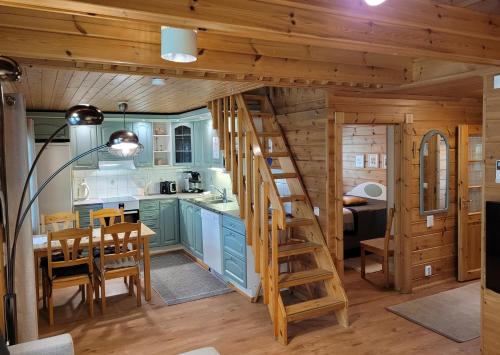 a kitchen and dining room with a staircase in a tiny house at Vuokatin Aateli Kreivi in Vuokatti