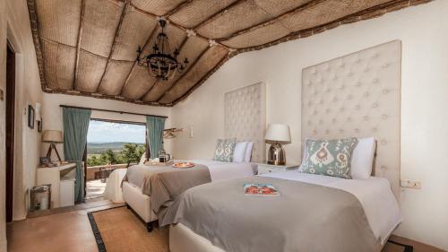 a bedroom with two beds and a window at Olarro Plains in Masai Mara