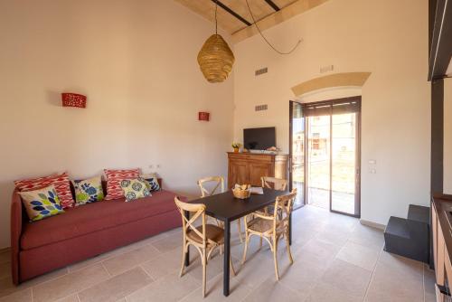 a living room with a red couch and a table at Masseria Specchiulla in Otranto