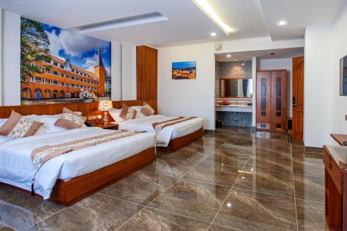 a hotel room with two beds and a kitchen at Royal Palace in Da Lat