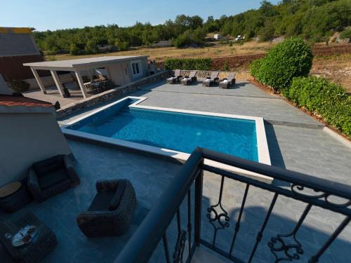 uma piscina com cadeiras numa varanda em Fantastic villa in Ugljane with private pool em Ugljane