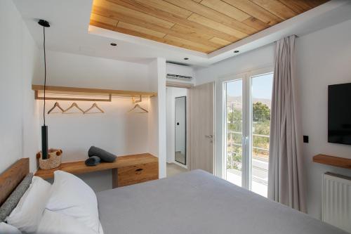a bedroom with a bed and a large window at Amelia villas Naxos in Naxos Chora