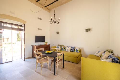 a living room with a table and a yellow couch at Masseria Specchiulla in Otranto