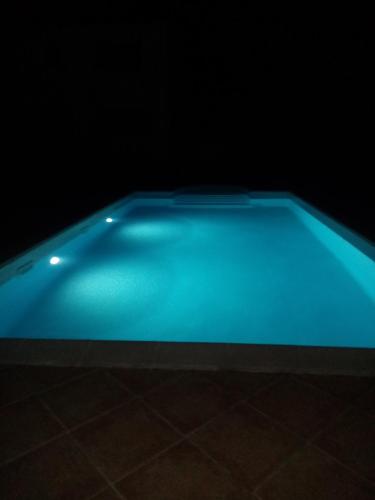 - une piscine bleue dans une pièce sombre dans l'établissement Villa maquis, à Afa