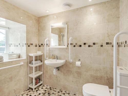 ein Badezimmer mit einem Waschbecken, einem WC und einem Spiegel in der Unterkunft Hebe in Dorchester