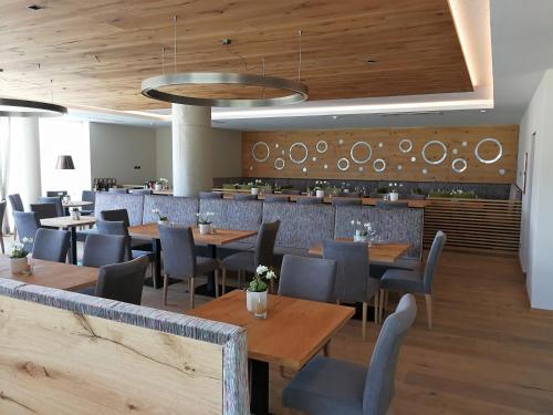 a restaurant with wooden tables and chairs and a bar at The Lodge Sporthotel - Golfclub Eppan in Appiano sulla Strada del Vino