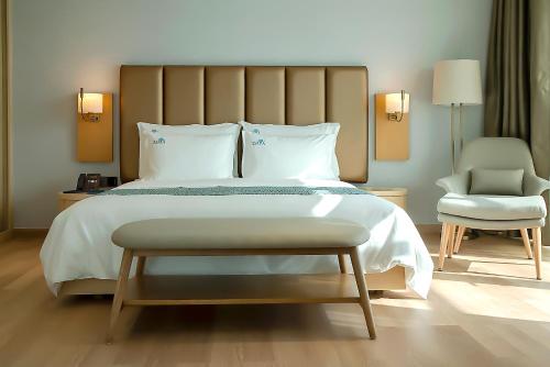 a bedroom with a large bed and a chair at Zoya Health & Wellbeing Resort in Ajman