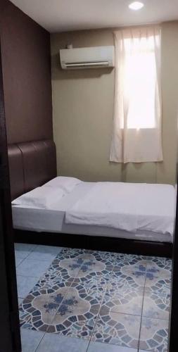 a bedroom with a bed and a window and a rug at Tabin Lodge Budget Stay in Lahad Datu