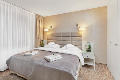 a bedroom with a large bed with two towels on it at Columna Medica in Łask