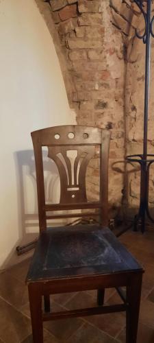 a wooden chair in a room with a stone wall at Penzion-apartmán U Johana in Moravská Třebová